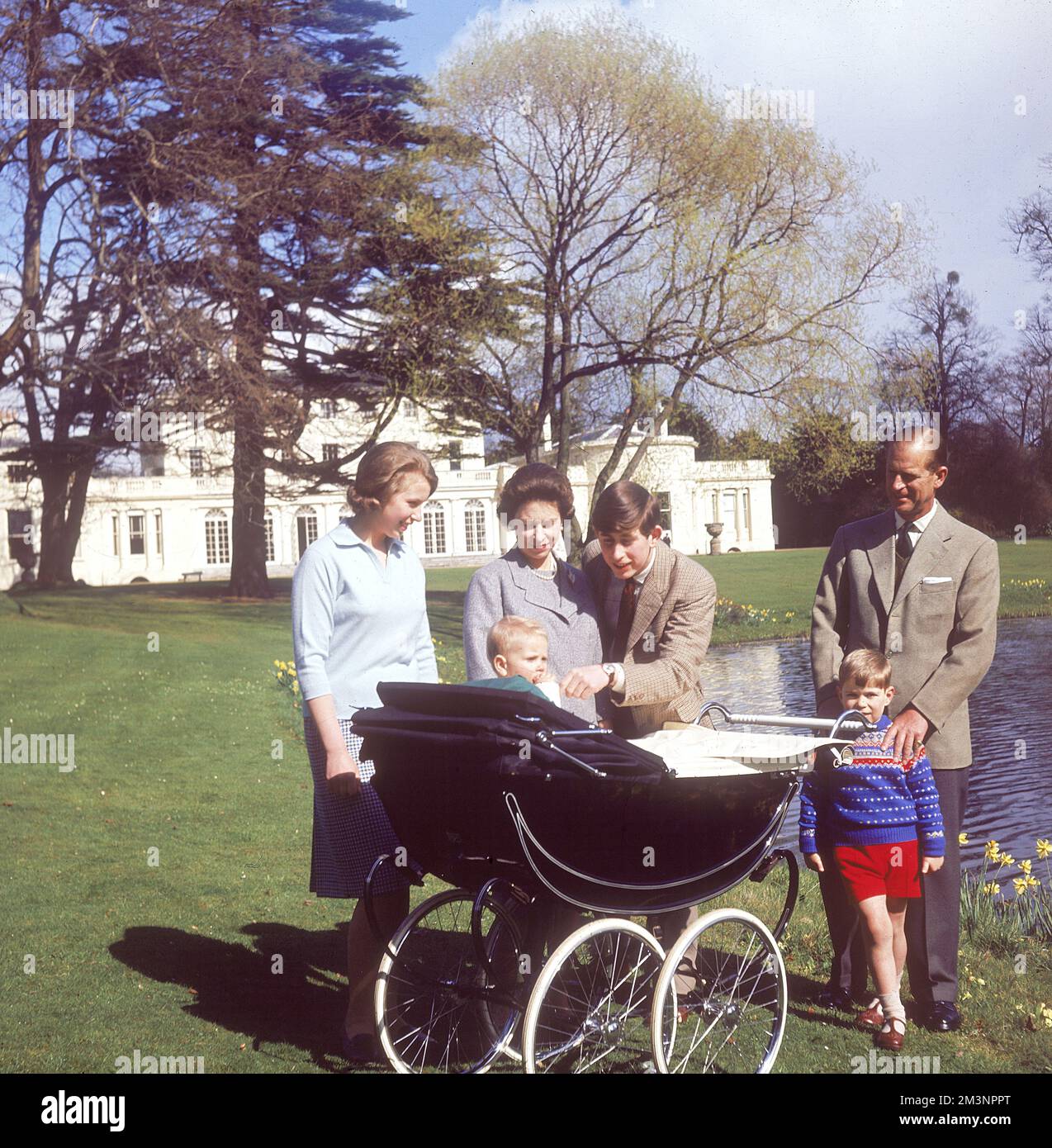 Königin Elizabeth und ihre Familie versammeln sich im April 1965 am Kinderwagen des einjährigen Prinzen Edward im Frogmore House. Von links: Prinz Philip, Herzog von Edinburgh, mit den Händen auf den Schultern von Prinz Andrew, Prinz Charles, der die Wange des Babys Prinz Edward, Königin Elizabeth II. Und Prinzessin Anne kitzelt. Datum: 1965 Stockfoto