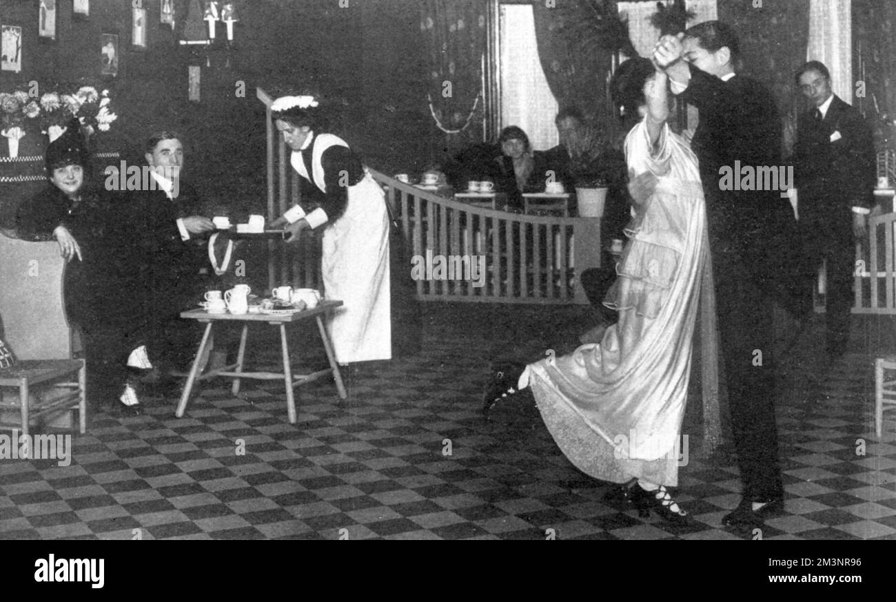 Ein neu eröffnetes Lokal für den Tangotee-Craze von 1913, am Harewood Place, Hannover Square in London. Der Salon wurde von Mr. F. H. Payne eröffnet und ähnelte einem privaten Ballsaal mit Unterricht und Tanzvorführungen von Senor Marquis und Miss Clayton, den gefeierten Tangotänzern aus dem Queens Theatre und dem Savoy Hotel, die hier abgebildet sind. Auf dem schwarz-weiß gefliesten Boden tanzen Sie elegant, während eine Kellnerin den Gästen in der Nähe Tee serviert. Datum: 1913 Stockfoto