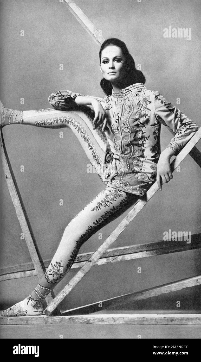 Die Skijacke aus Baumwollsamt mit charakteristischem florentinischem Aufdruck wurde in dieser Saison von einer Jersey-Hose aus Second Skin-Seide kombiniert, die passend zu den Trompe-l'oeil-Stiefeln bedruckt wurde. Beide von Emilio Pucci. Datum: 1965 Stockfoto
