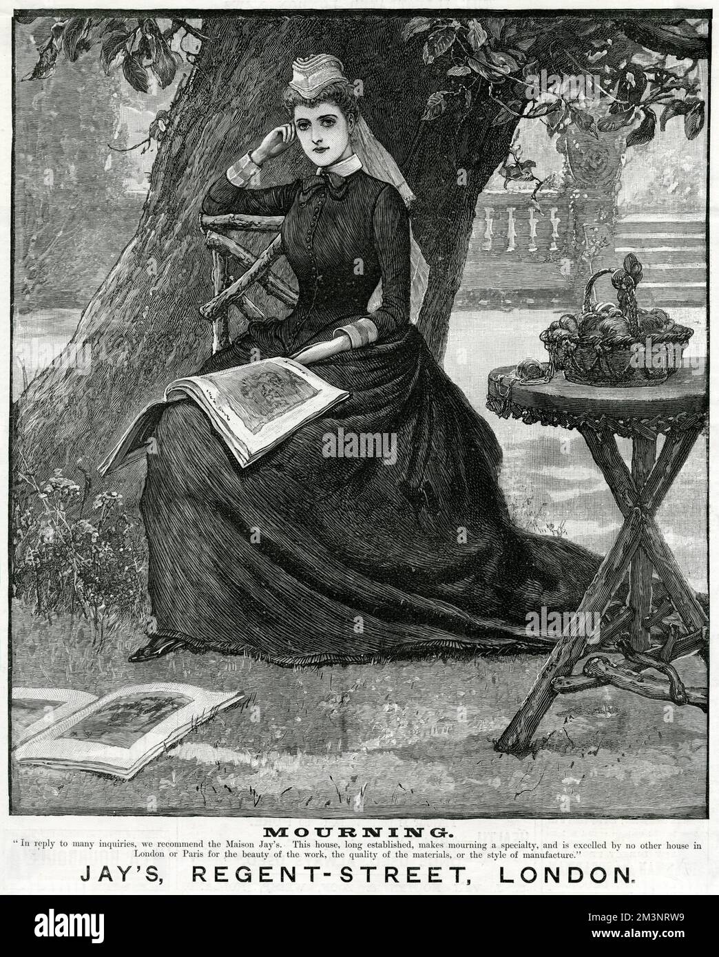 Eine nachdenkliche Frau sitzt unter einem Baum und modelt Trauerkleidung von Jay's of London. Ihr Arbeitskorb steht auf einem rustikalen Tisch, und illustrierte Zeitschriften liegen zu ihren Füßen. Datum: 1888 Stockfoto