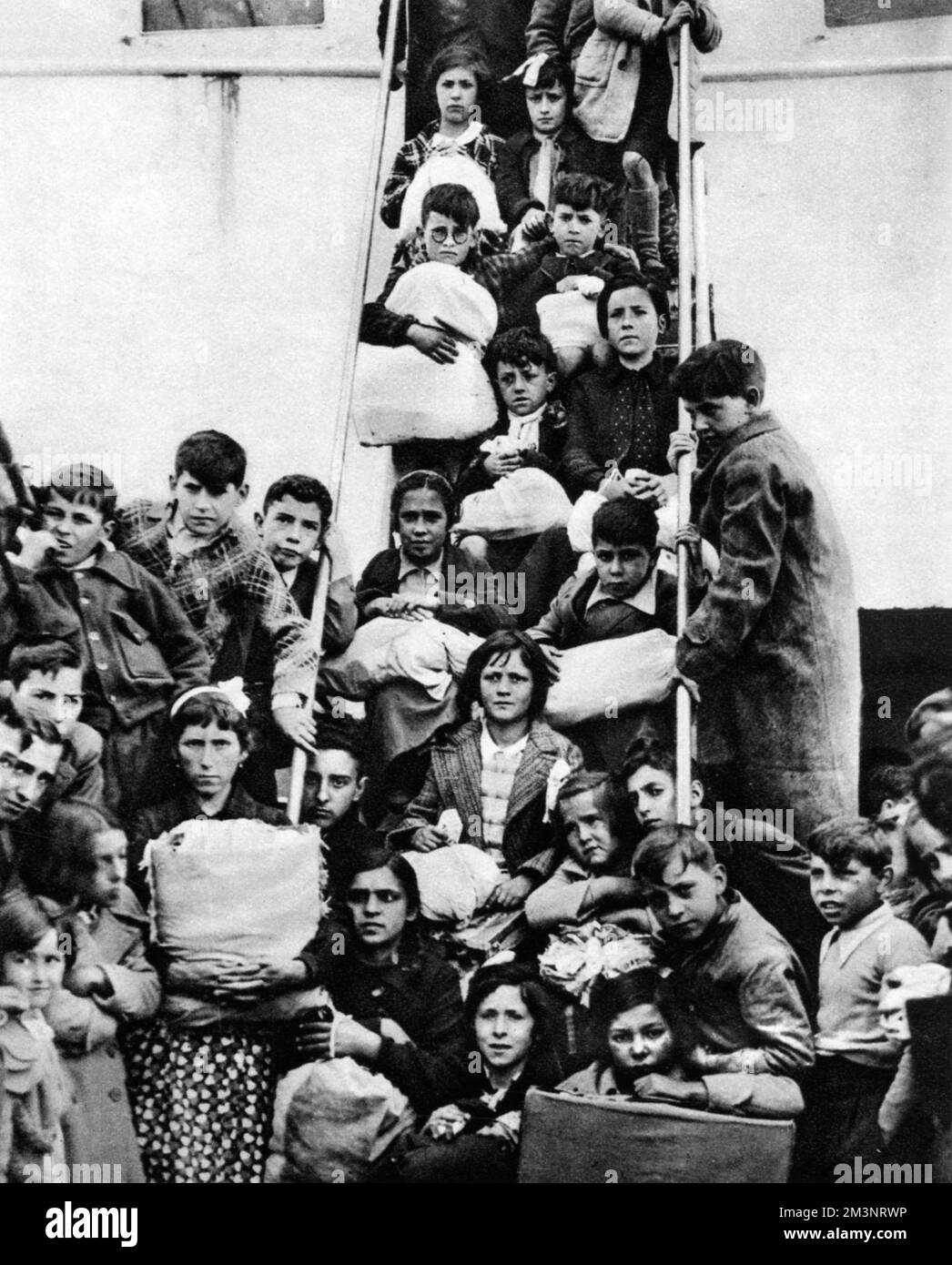 Kinder aus Bilbao warten auf die Landung vom spanischen Compania Transaltantikliner „Habana“ am Southampton Docks - Kinderflüchtlinge wurden während des Spanischen Bürgerkriegs 1937 nach England evakuiert. Datum: Mai 23. 1937 Stockfoto