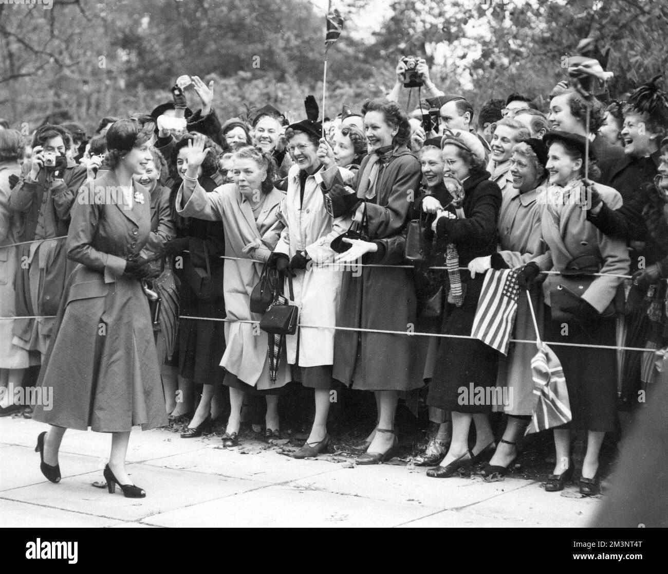 Prinzessin Elizabeth wird von Fahnenschwenkern begrüßt, während sie nach ihrer kanadischen Tour im Jahr 1951 durch Washington DC spaziert. Datum: 1951 Stockfoto