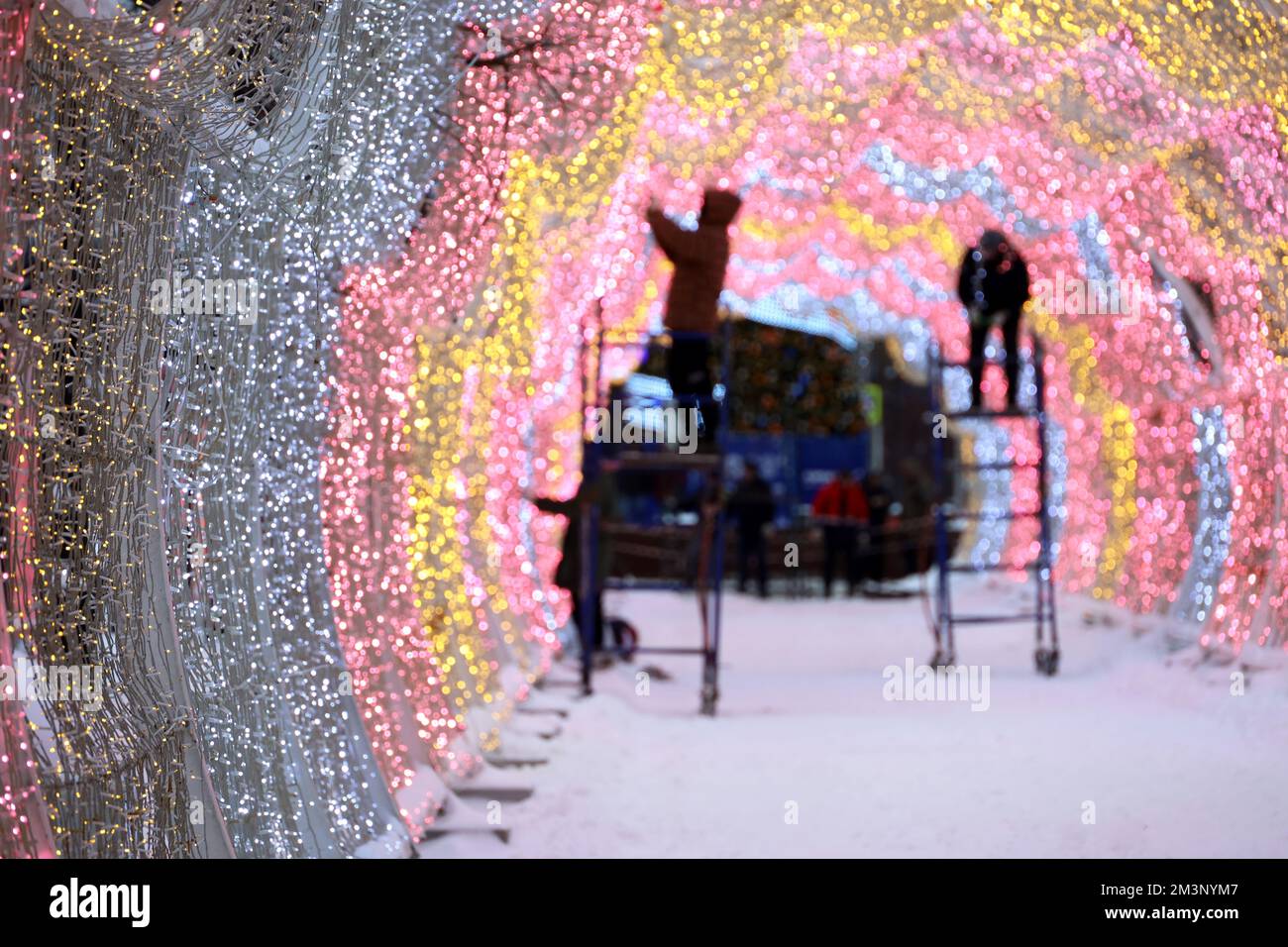 Silvester-Ornamente auf der Straße der Stadt, Arbeiter dekorieren den beleuchteten Bogen in der Winterstadt. Vorbereitung auf die Weihnachtsferien Stockfoto