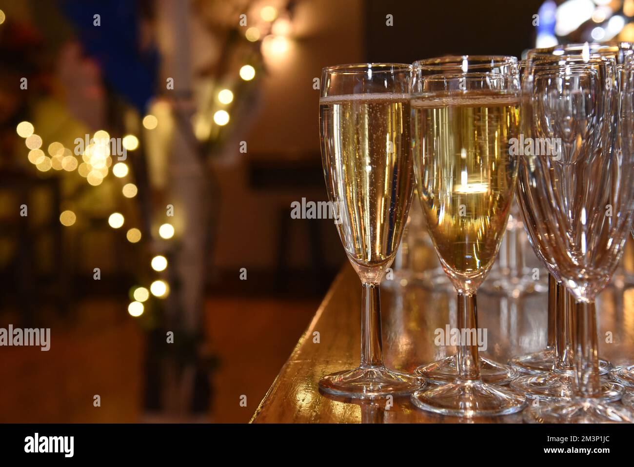 Champagnergläser mit märchenhaften Lichtern als sanfter Fokus im Hintergrund Stockfoto