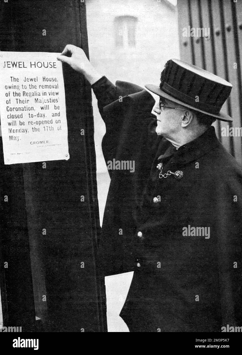 Ein Aufseher aus Yeoman, der Lord Chamberlains Kündigung auf dem Wakefield Tower im Tower of London festklebt und ankündigt, dass der Ort aufgrund der Entfernung der Regalia bis Mai 17 geschlossen sein wird. Vor der Krönung wurden die Juwelen bei den Juwelieren Garrard aufbewahrt, wo sie dekoriert wurden. Datum: 1937 Stockfoto