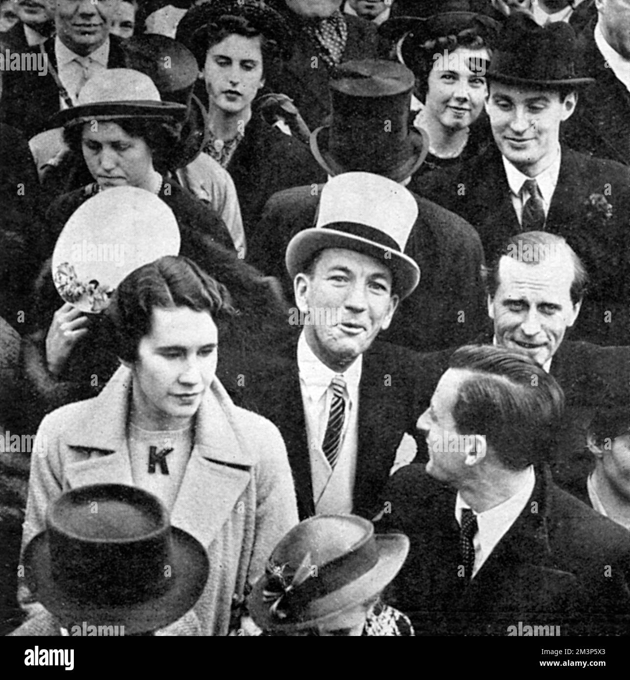 Noel Coward (Sir Noel Peirce Coward, 1899-1973), englischer Schauspieler, Sänger, Dramatiker, regisseur und Komponist mit einem grauen Hut und vor dem Buckingham Palace, wo er am 12. Mai 1937 unter den Zuschauern war, die die Krönungswende von König George VI. Sahen. Datum: 1937 Stockfoto