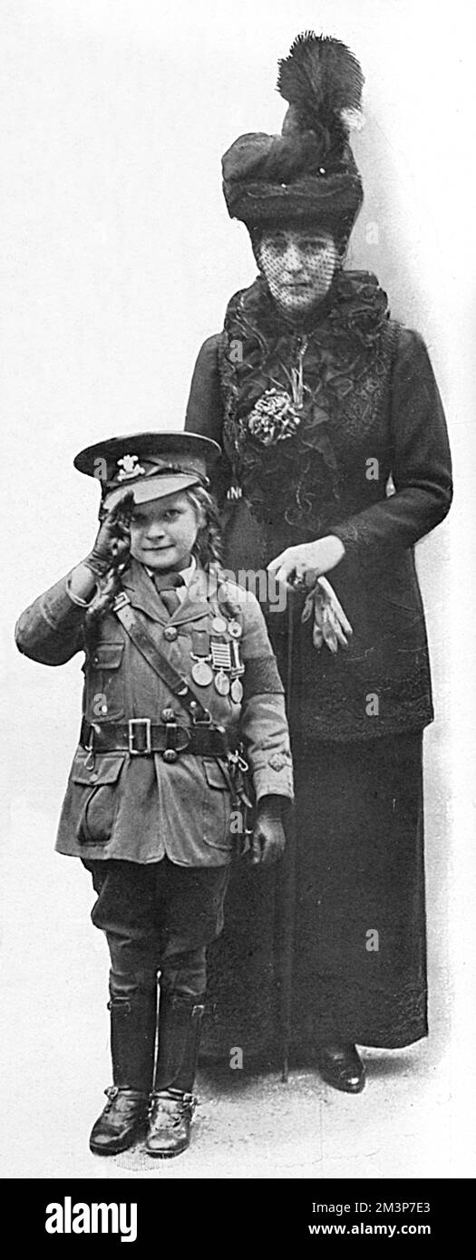 Königin Alexandra fotografierte mit Miss Jeannie Jackson, der Tochter eines Bergarbeiters in Burnley, der 1.100 Dollar an Bullen auf den Straßen von Burnley sammelte, um Kriegsgelder in einer Miniaturuniform zu erhalten. Für 450 wurde ein Krankenwagen namens "Young Kitchener" gekauft und der Rest wurde übergeben, um Komfort für die Truppen zu kaufen. Das kleine Mädchen wurde der Königin im Marlborough House im Juli 1916 vorgestellt. Datum: 1916 Stockfoto