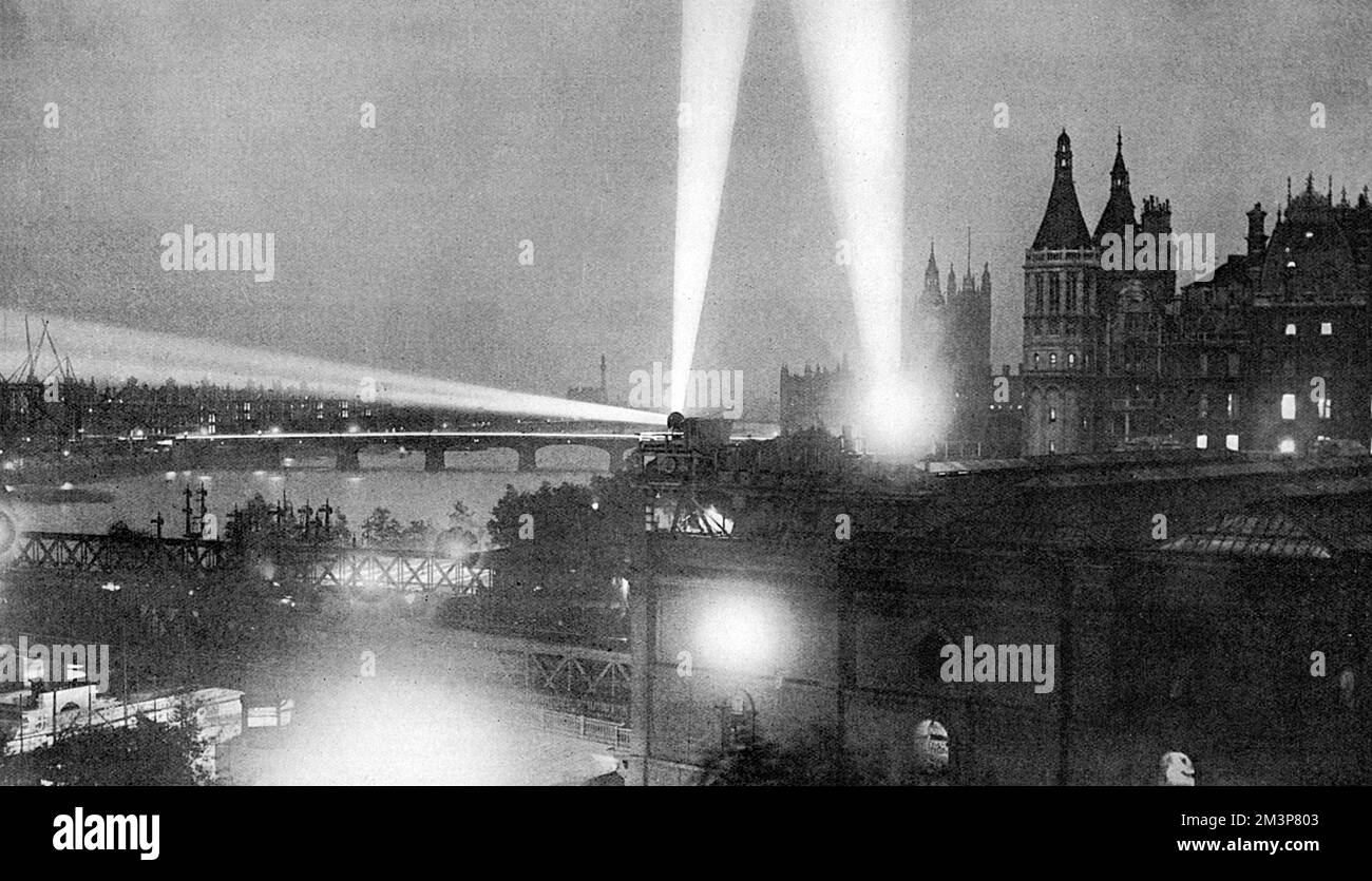 Im September 1914 warfen Scheinwerfer Licht über die Skyline von London, auf der Suche nach deutschen Zeppelin-Flugzeugen. Der Tatler sagt: "Mit dunklen Straßen, öffentlichen Häusern, die um elf Uhr geschlossen sind, Soldaten überall und Suchlichtern, die in alle Richtungen blinken, stellt London im Moment einen Aspekt dar, der ausreicht, um den ältesten Bewohner zu erschrecken und uns in einem kleinen Maß die Realität des Krieges vorzustellen." Datum: 1914 Stockfoto