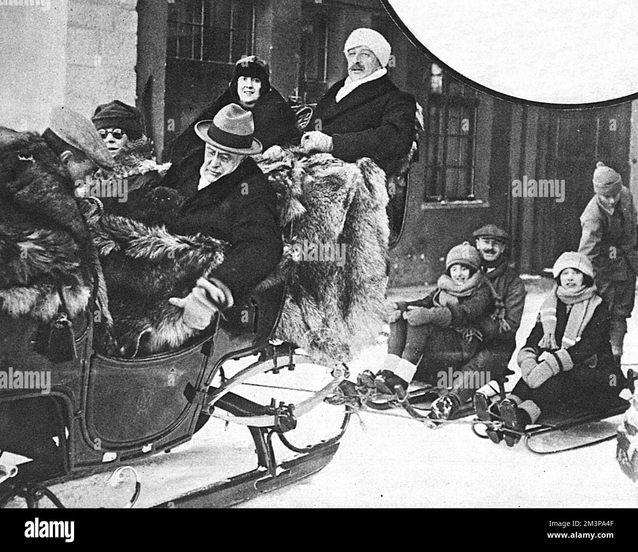 Harry Gordon Selfridge (1856-1947), in der Schweiz in der Mitte des Schlittens neben Mrs. St. George, Ich Bin'S Lord und Lady Headfort sitzen hinten im Schlitten, bedeckt von Pelzbalnketten. Datum: 1924 Stockfoto