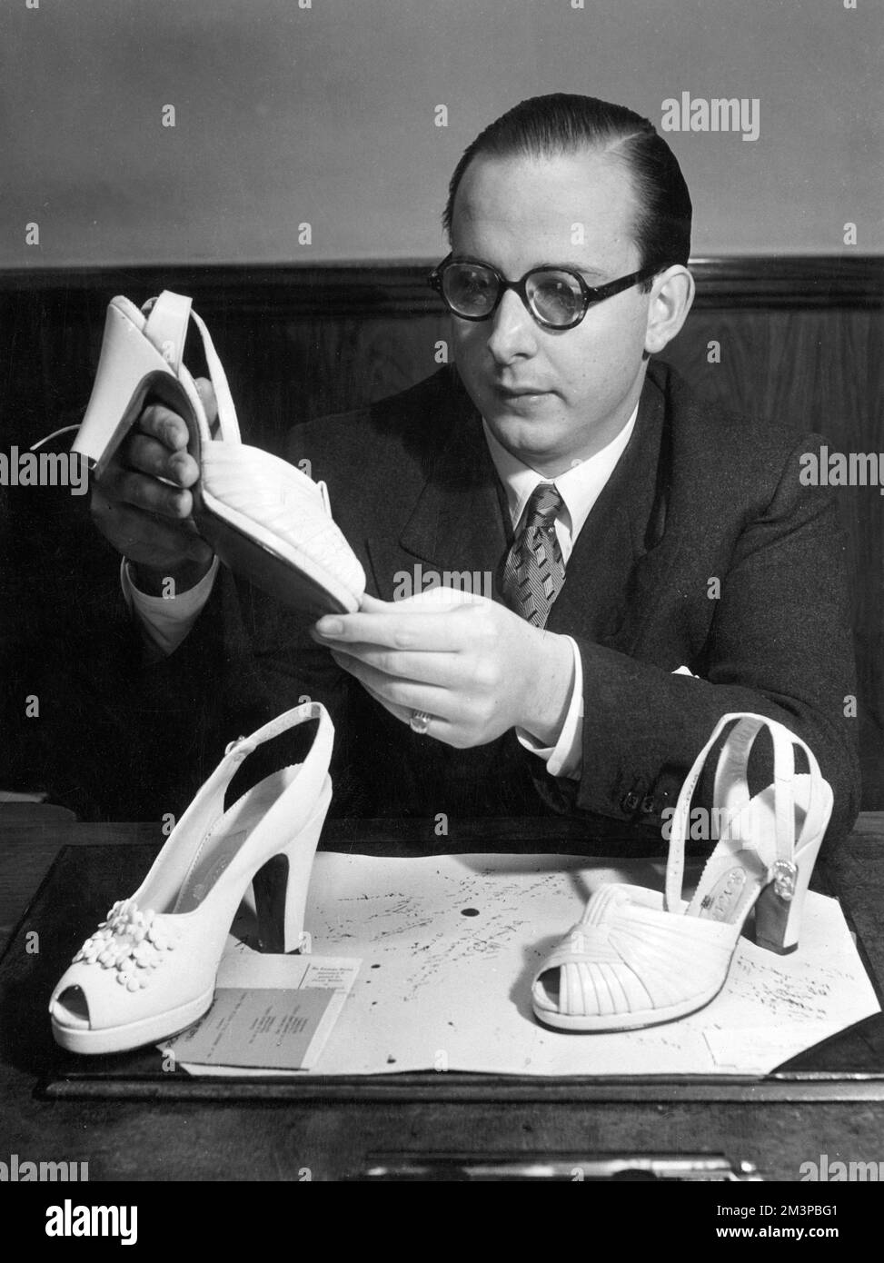 Edward Rayne aus der berühmten Rayne-Schuhdynastie, gegründet von seinen Großeltern im Jahr 1889 und Schuhmachern für Könige, die in den 1950er Jahren ein Paar Schuhe der Firma in Betracht ziehen. Datum: 1952 Stockfoto