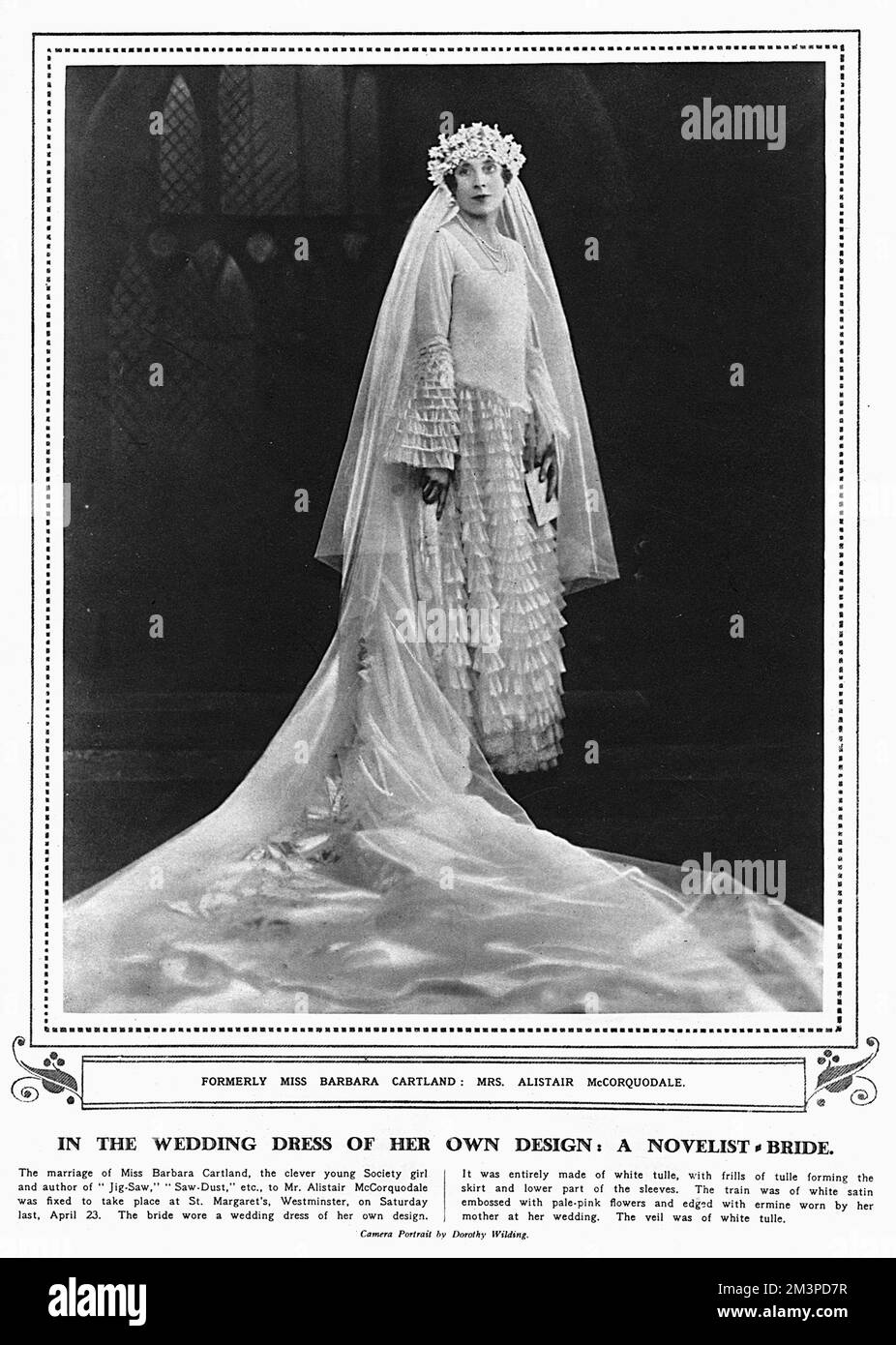 Dame Mary Barbara Hamilton Cartland (1901-2000), verheiratet mit Frau Barbara McCorquodale, britische Schriftstellerin. Im Hochzeitskleid, das sie für ihre Hochzeit mit Alistair McCorquodale im April 1927 entwarf. Das Kleid war komplett aus weißem Tüll gefertigt, mit Rüschen aus Tüll, die den unteren Rock und den unteren Teil der Ärmel bilden. Der Zug war aus weißem Satin geprägt mit blassrosa Blumen und umrandet mit Hering, das ihre Mutter auf ihrer Hochzeit trug. Der Schleier war aus weißem Tüll. Datum: 1927 Stockfoto