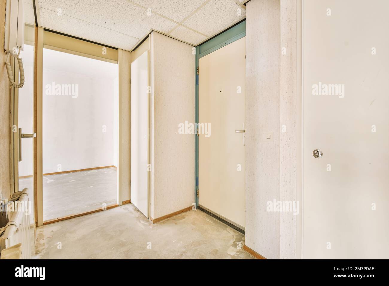 Das Innere eines Raumes ohne Möbel oder Gegenstände und eine offene Tür, die zu einem anderen Raum führt Stockfoto