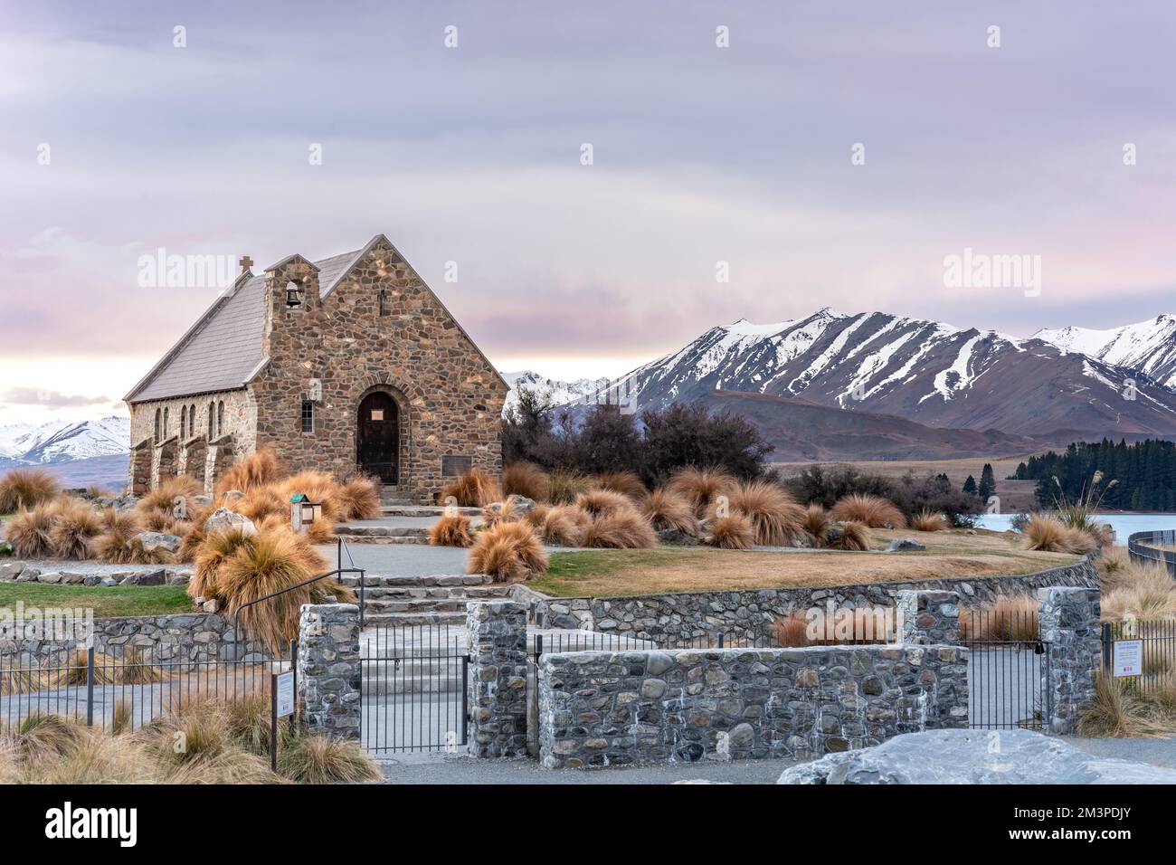 Sonnenaufgang auf die Kirche des guten Hirten im späten Winter mit wunderschönen schneebedeckten südlichen Alpen im Hintergrund. Stockfoto