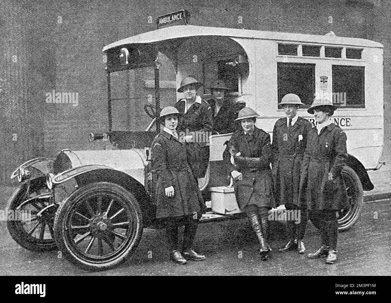 Krankenwagenmädchen aus dem Londoner County Council, die mit ihrem Krankenwagen neue Schrapnell-Helme tragen. 1918 Stockfoto