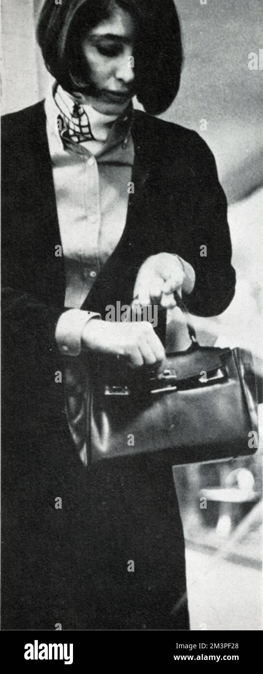Jackie Modlinger, englische Moderedakteurin des Ambassador Magazine (eine Publikation, die sich der Werbung für britische Mode im Ausland widmet). Sie sieht sich in der Arkade des Hilton Hotels mit einem jadegrünen Cacharel-Crepon-Shirt und schwarzer Strickjacke und Rock um. Datum: 1966 Stockfoto