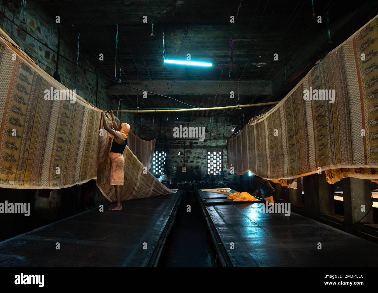 Indischer Arbeiter, der Textilien nach manuellem Siebdruck trocknet, Rajasthan, Jaipur, Indien Stockfoto