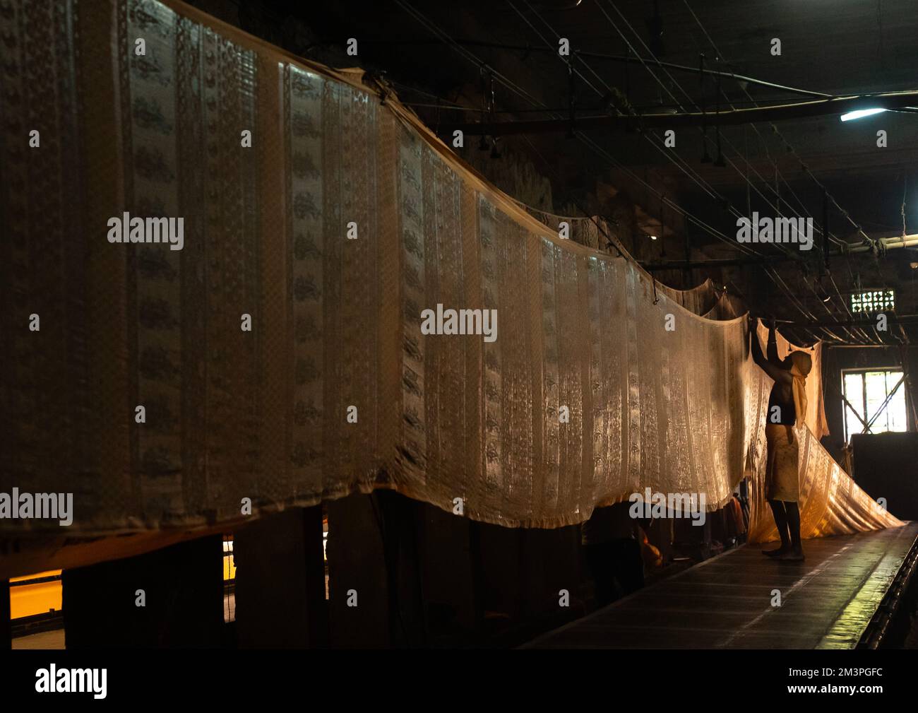 Indischer Arbeiter, der Textilien nach manuellem Siebdruck trocknet, Rajasthan, Jaipur, Indien Stockfoto