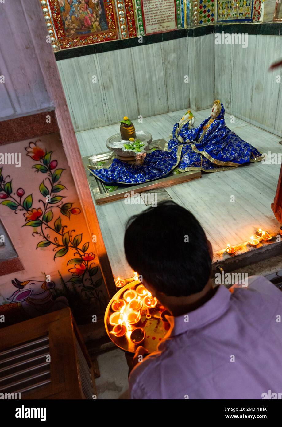 Ein indischer Mann, der Kerzen in einem Tempel für Diwali, Rajasthan, Jaipur, Indien anbietet Stockfoto