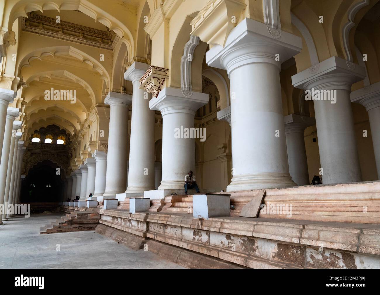 Die Menschen sitzen in der Säulenhalle des Thirumalai Nayakar Palastes, Tamil Nadu, Madurai, Indien Stockfoto