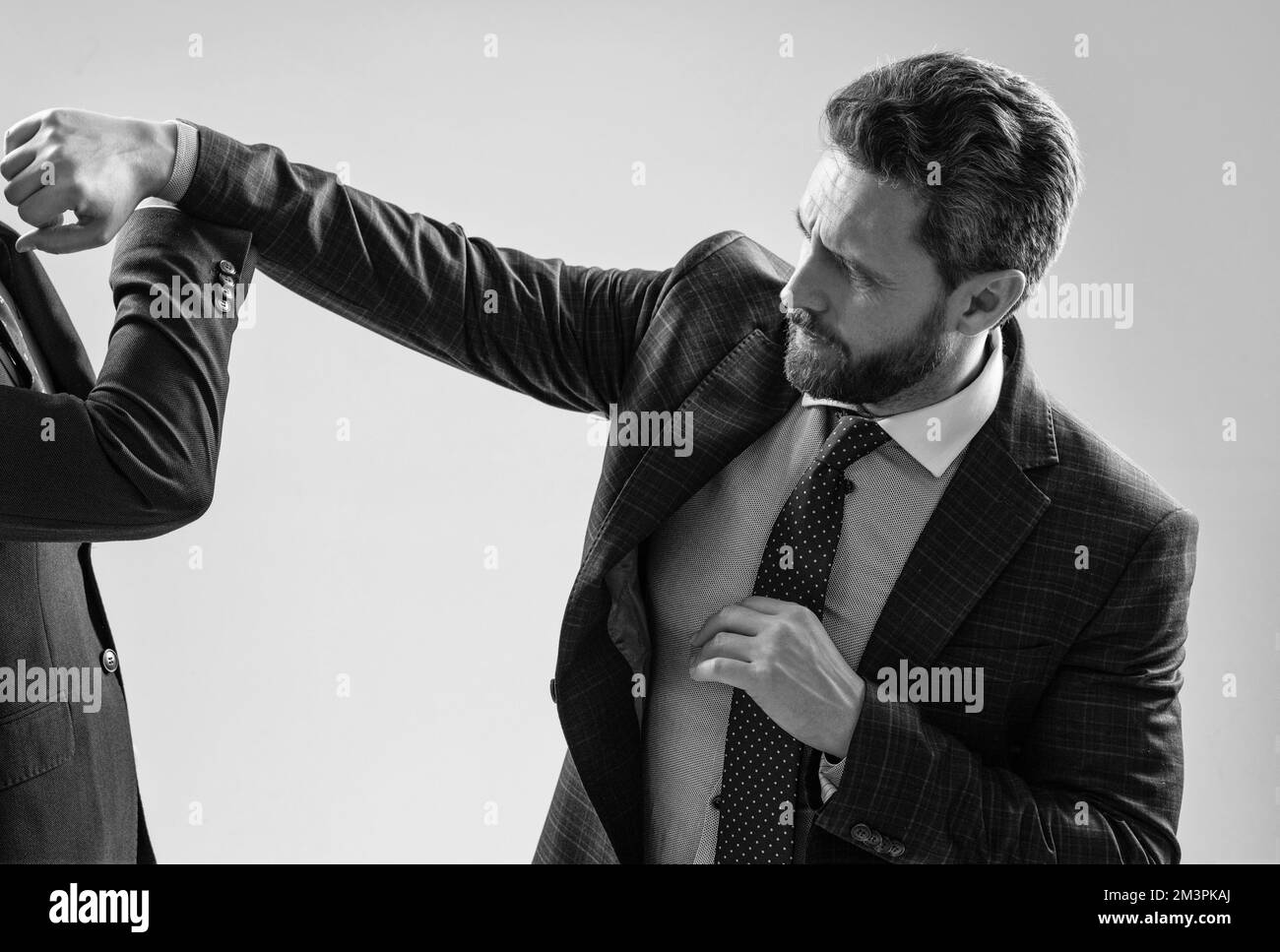 Aggressiver professioneller Mann Geschäftsmann Punch Mitarbeiter mit Faust grauen Hintergrund, kämpfen Stockfoto