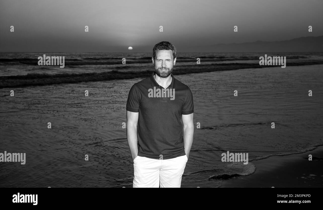 Fröhlicher Mann über dem Meer am sonnigen Sommerstrand, Urlaub Stockfoto