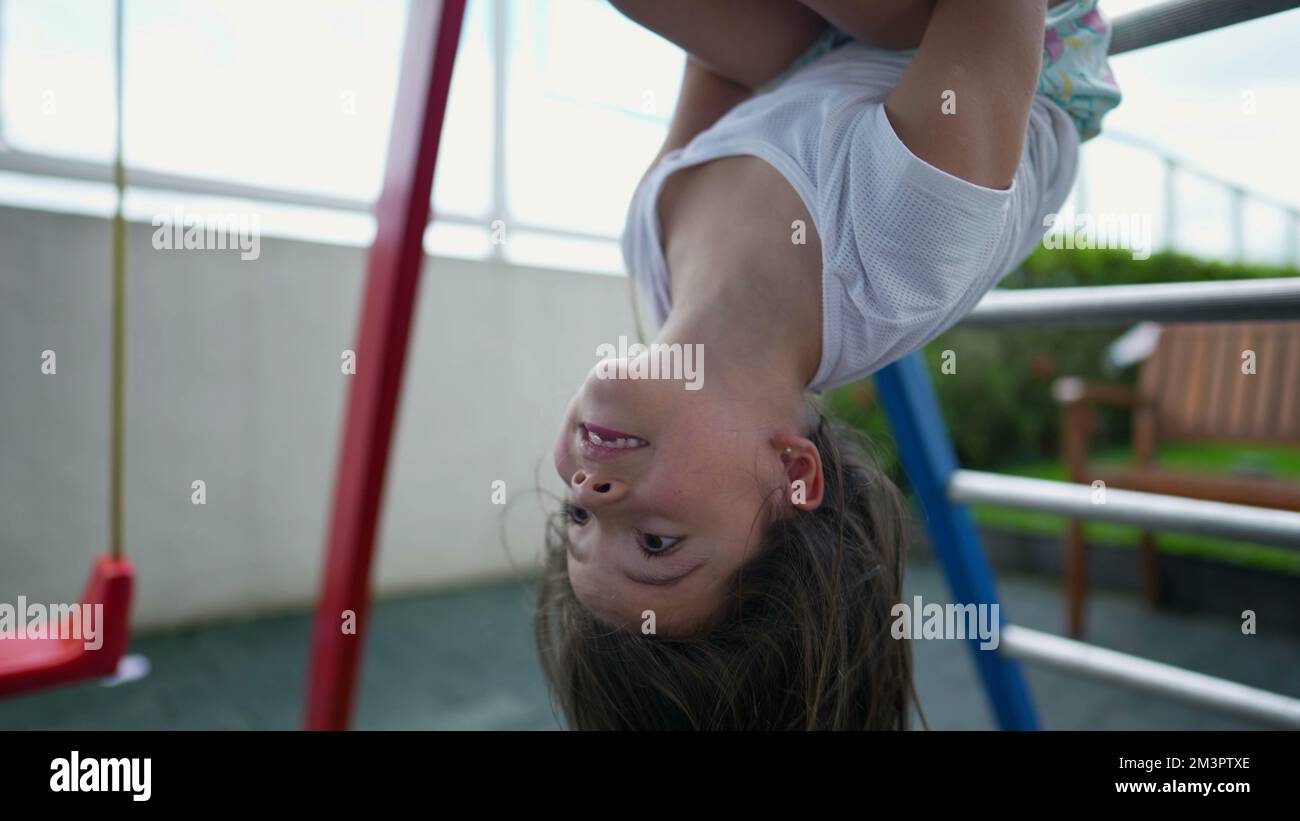 Ein Kind, das vom Affen fällt, ein Kind, das kopfüber hängt, fällt auf den Boden Stockfoto