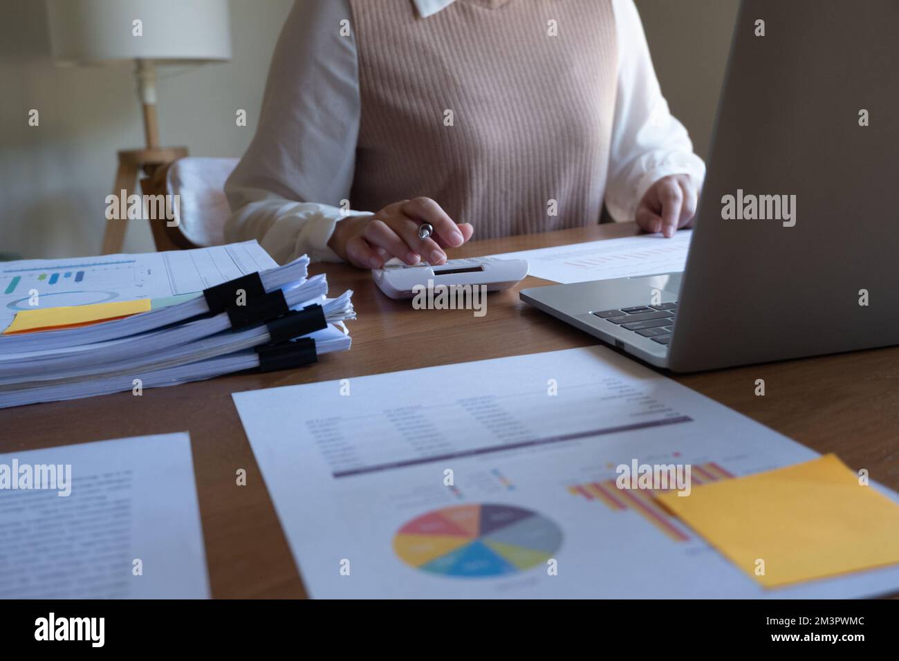Zugeschnittenes Bild einer professionellen Geschäftsfrau, Unternehmerin oder Buchhalterin, die an ihrem Schreibtisch mit einem Taschenrechner oder Laptop an einem Finanzbericht arbeitet Stockfoto