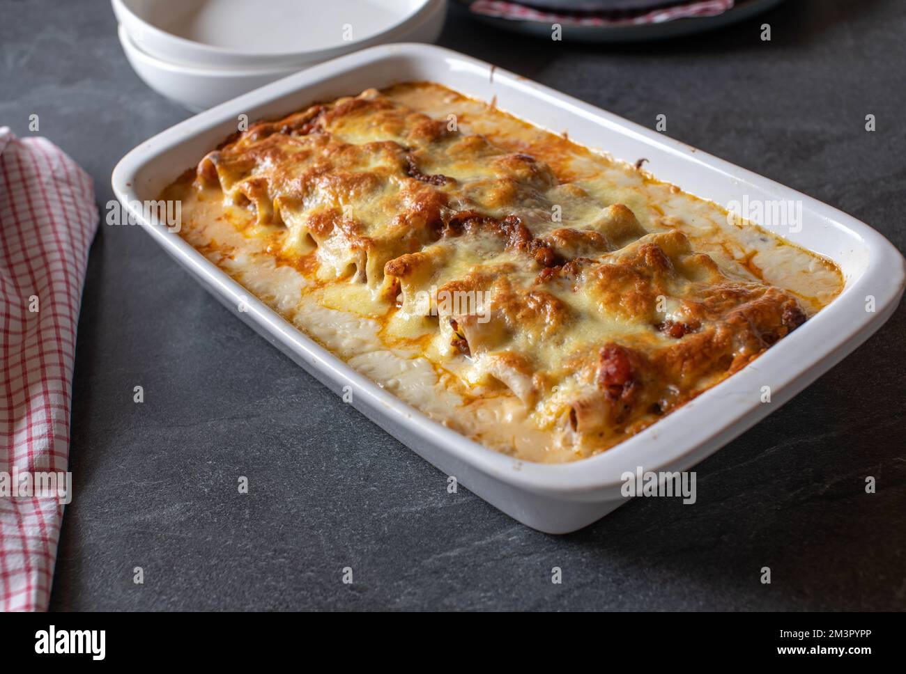 Frisch gebackener Pasta-Auflauf mit gefüllten Cannelloni. Gebacken mit Bolognese und Béchamel-Sauce. Garniert mit Mozzarella-Käse. Das echte Leben Stockfoto