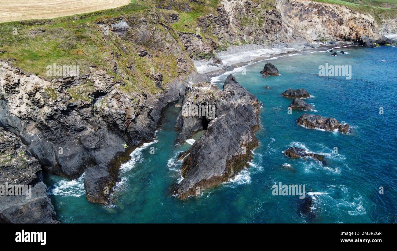 Steile Klippen an der Küste. Türkisfarbenes Wasser des Atlantischen Ozeans. Naturschönheiten Irlands, West Cork. Die felsige Küste der Keltischen See. Stockfoto