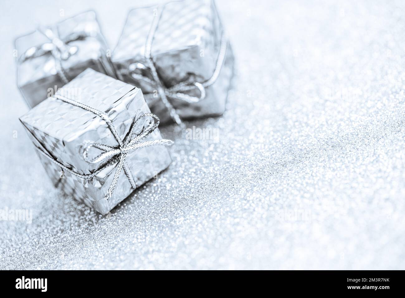 Silberne Geschenkboxen zur Dekoration auf glitzerndem Hintergrund Stockfoto