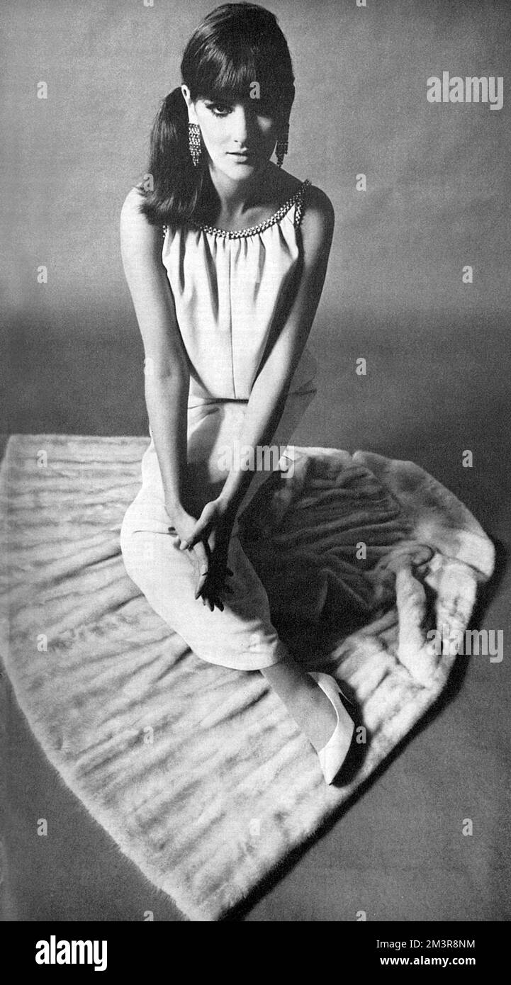 Foto aus einer Harrods-Werbung. Das Kleid wurde von Yves St Laurent inspiriert und wurde exklusiv für den Laden entworfen. Das schlanke Kleid war aus Moos-Crepe, der Hals war reich an Perlen und Kristallperlen. Verfügbar im „Designer Room“ AIM für die Altersgruppe der 25-35-Jährigen, die sich selbst eine modische Raffinesse wünschen. Datum: 1965 Stockfoto