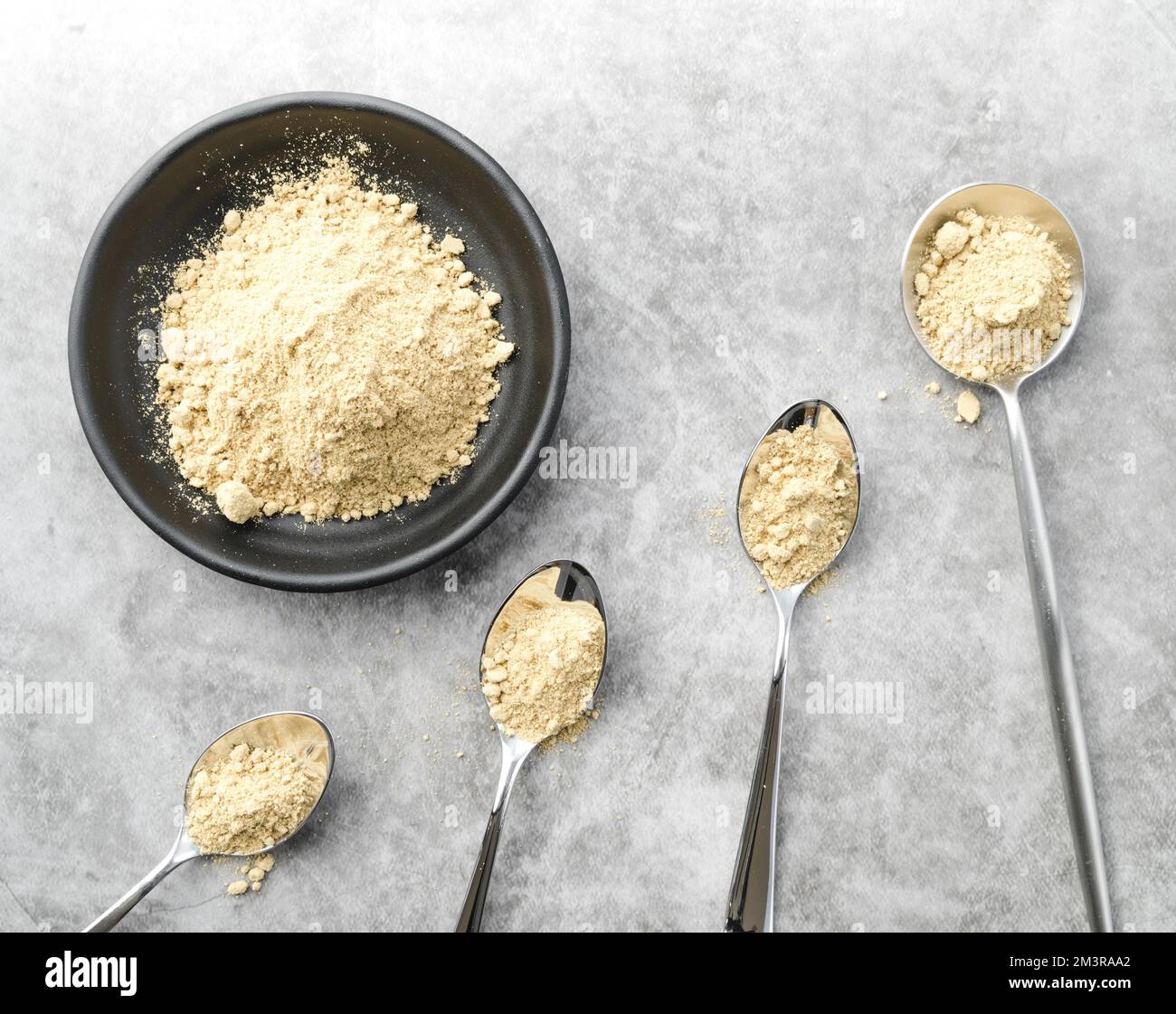 Bio-Lebensmittelpulver in Schüssel und Löffeln, Auflösung und hochwertige, wunderschöne Fotos Stockfoto
