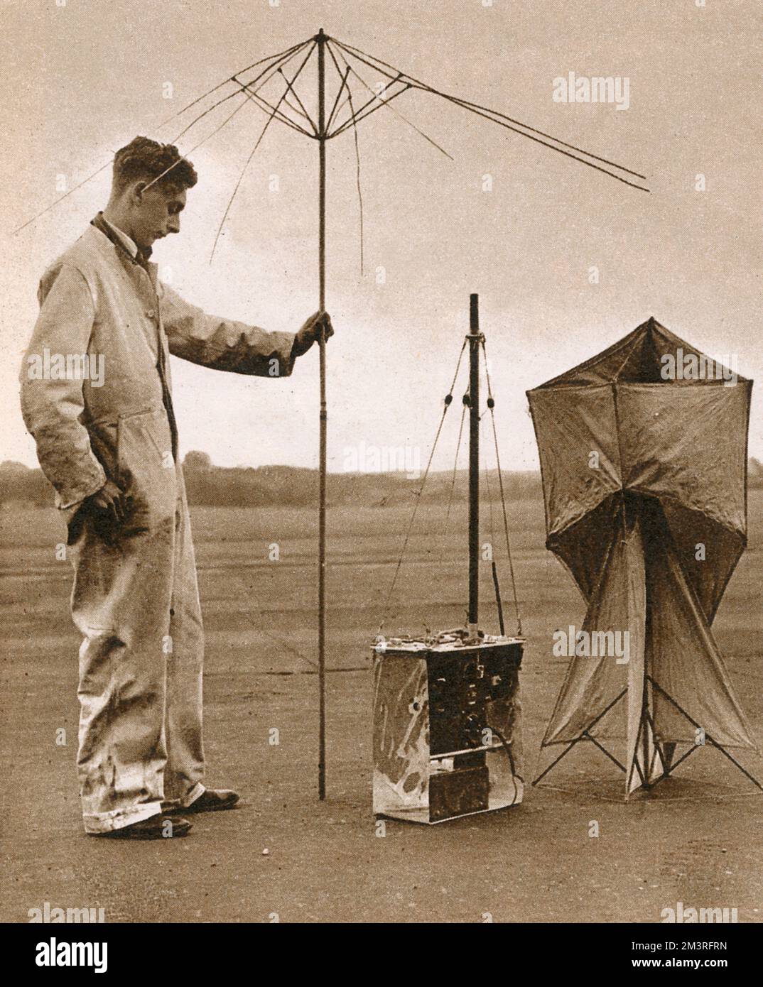 Ein Mann untersucht ein Funkgerät eines gefangenen Heinkel III-Flugzeugs. Es kann entweder mit Drachen- oder Stabantenne verwendet werden und blitzt bei bestimmten Wellenlängen automatisch den Notruf. Datum: 1940 Stockfoto