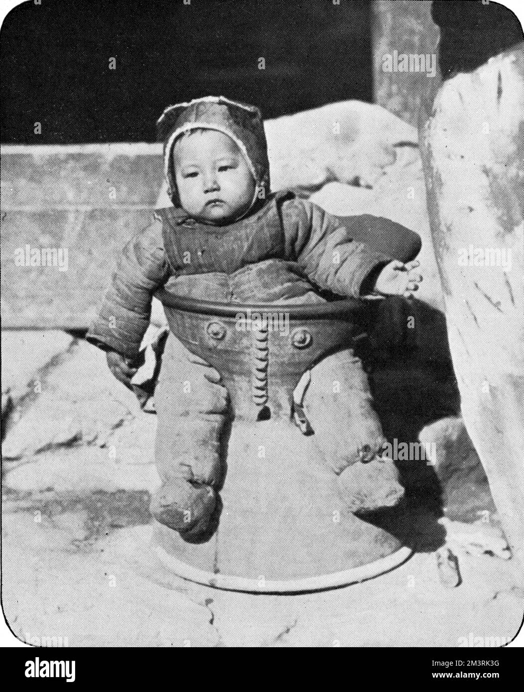 Eine offenbar beliebte Praxis in Henan, bei der Säuglinge in eine Bronzeschale gelegt wurden, während ihre Mutter weg war. Für das arme Kind ist eine Flucht unmöglich! 1927 Stockfoto