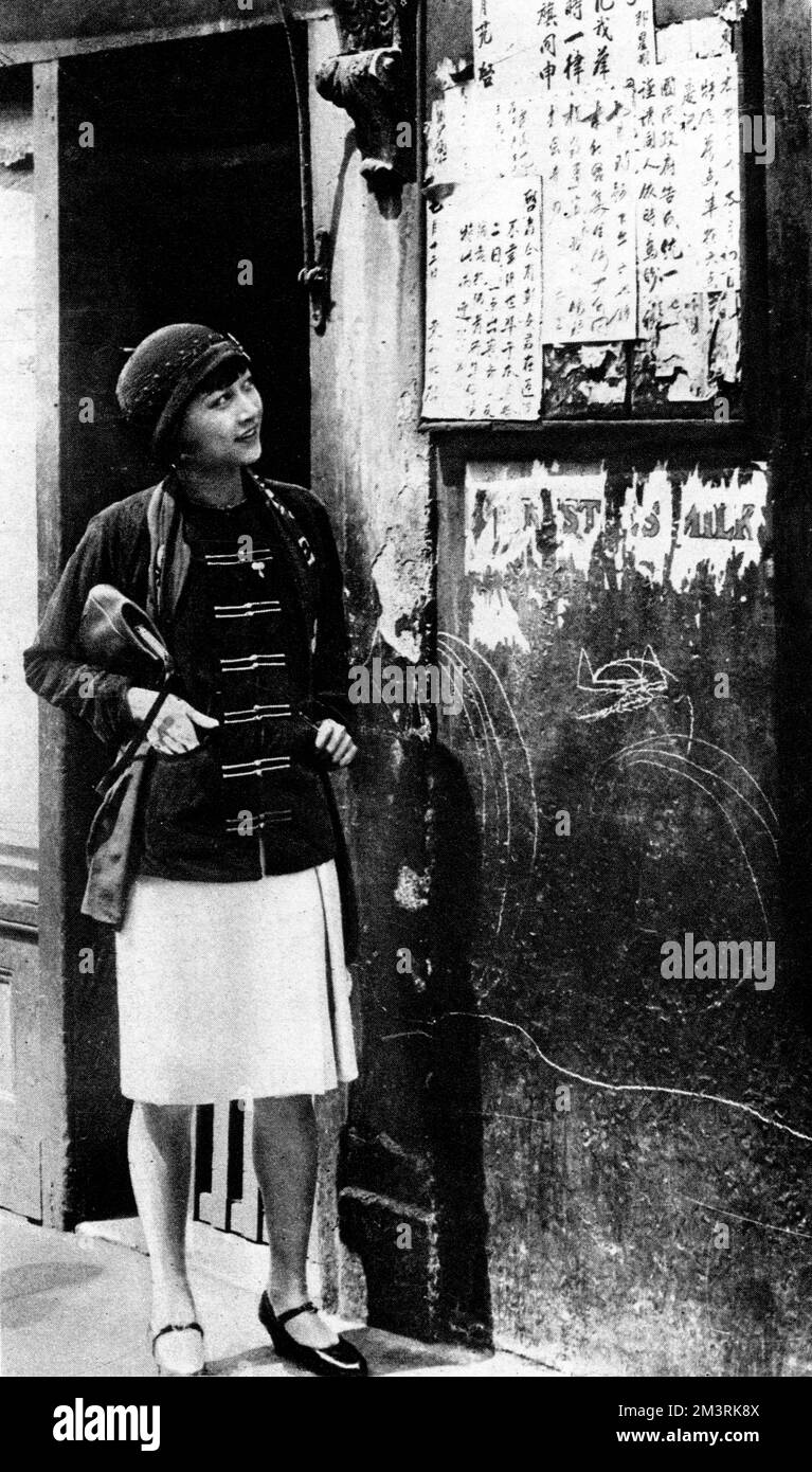 Die chinesisch-amerikanische Schauspielerin Anna May Wong (1905-1961) liest eine Speisekarte in Londons Chinatown in Limehouse. 1928 Stockfoto