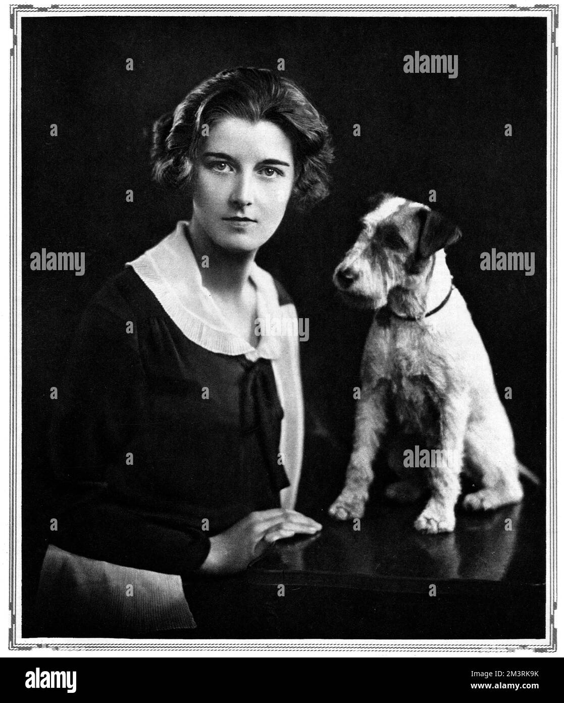 Eileen Hood, Schwester von Viscount Bridport, und Tochter von Maurice Hood, R. N.V.R., posiert neben einem Hund. 1928 Stockfoto
