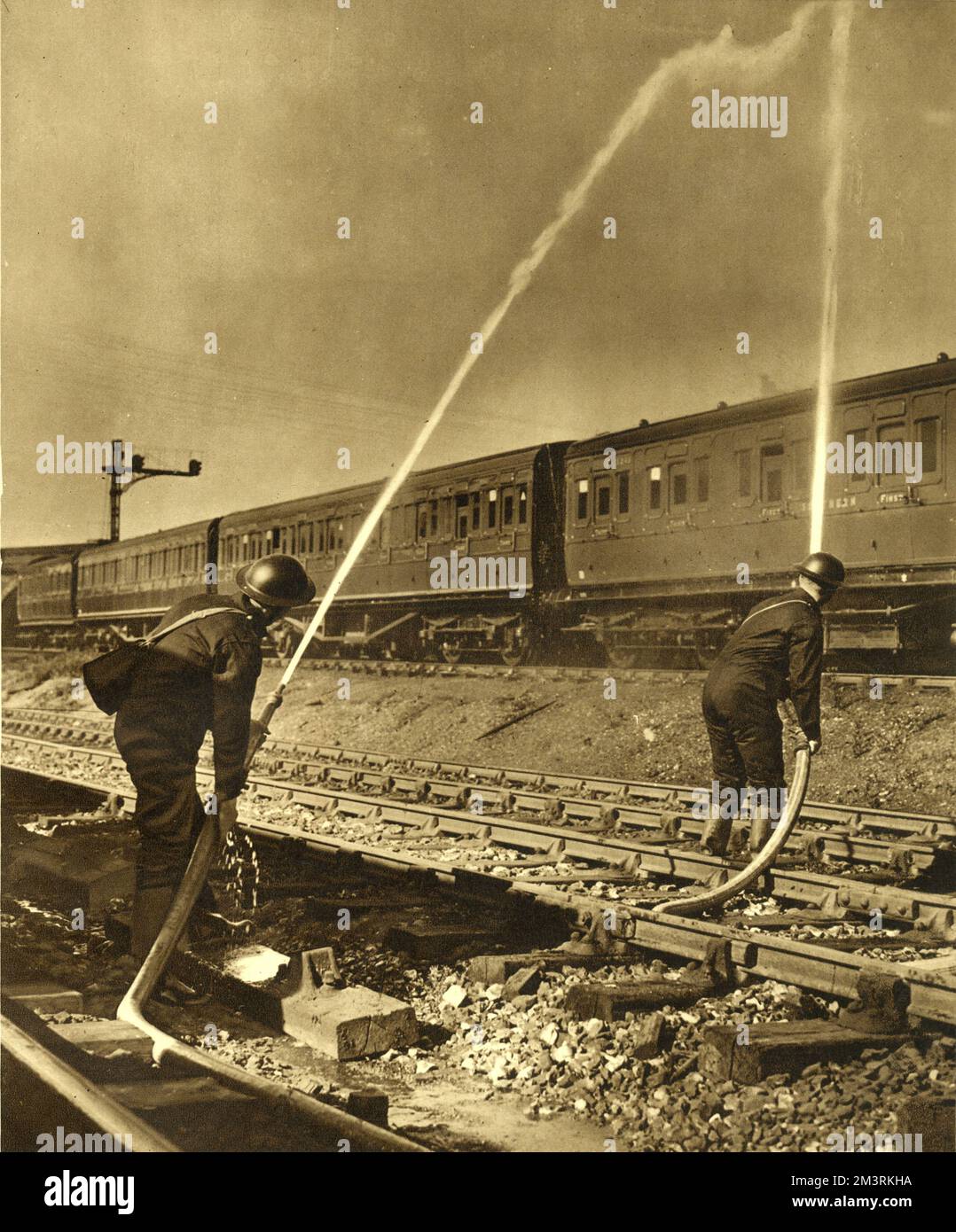 Feuerwehrleute, die für die Southern Railway arbeiten, sprühen Wasser auf das Dach eines Zuges. Southern Railway beschäftigte achtzig A.F.S. Männer, um Brände zu bekämpfen, die durch Brandbomben der Luftwaffe verursacht wurden. 1940 Stockfoto