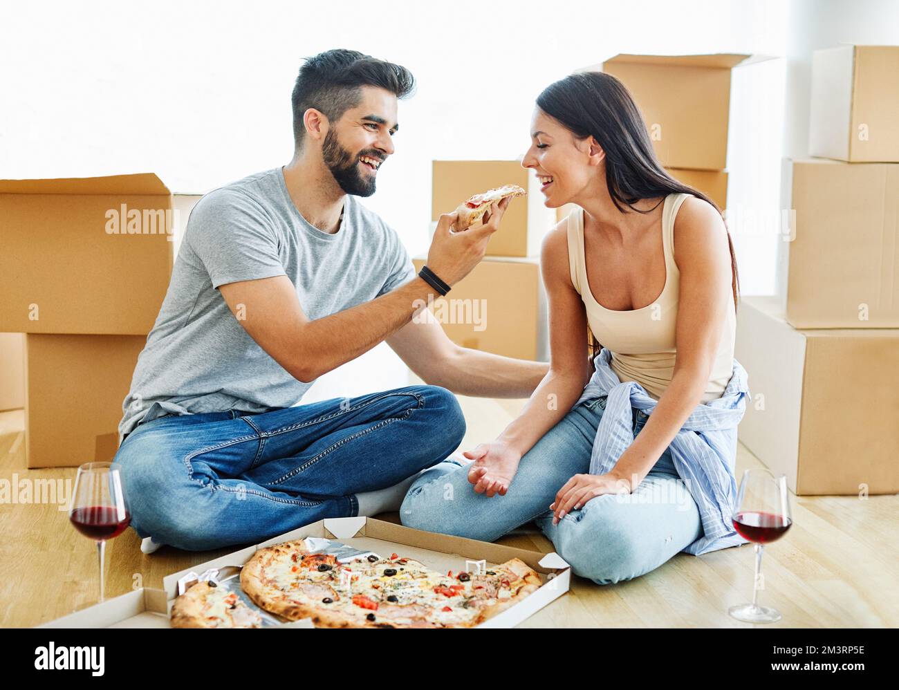 Frau Paar Mann Box Haus Umzug glücklich Wohnung zusammen romantische Verlagerung Pizza essen Stockfoto