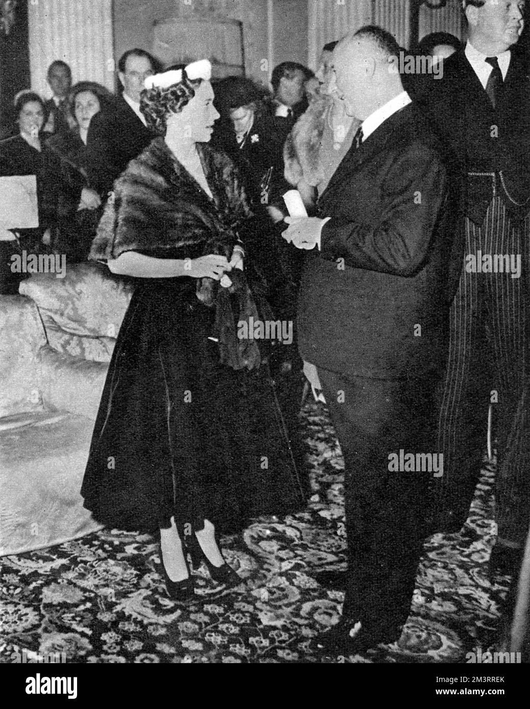 Prinzessin Margaret spricht mit Christian Dior nach einer Show seiner Winterkollektion im Blenheim Palace in Oxfordshire. Margaret war ein großer Fan des französischen Designers und trug viele seiner Kleider. Datum: 1954 Stockfoto