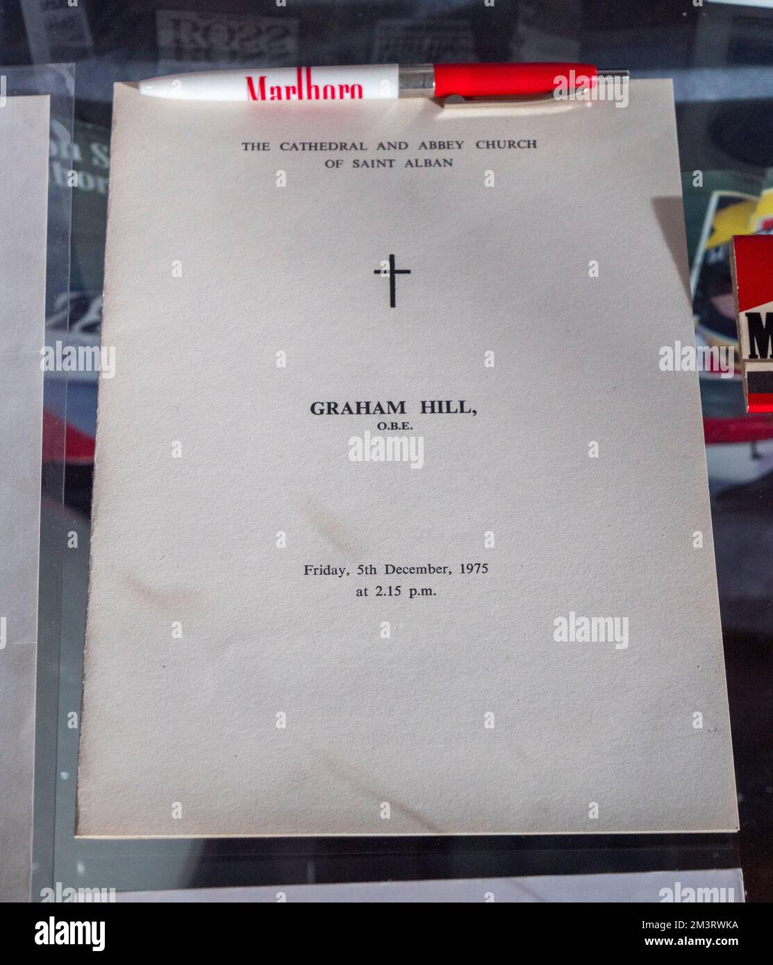 Service Card von Graham Hill's Begräbnis nach seinem tödlichen Flugzeugabsturz (Dezember 1975) in der Grand Prix Exhibition, Brooklands Museum, Surrey, Großbritannien. Stockfoto