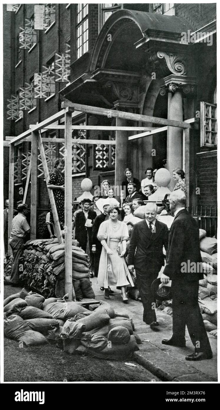 Königin Elizabeth (später die Königinmutter) zeigte sich kurz vor der Kriegserklärung im September 1939 beim Besuch des Vincent Square Infants' Hospital in Victoria, London. Beachten Sie die mit Klebeband versehenen Fenster und Sandsäcke, die bereits als Vorsichtsmaßnahme gegen Luftangriffe verwendet werden. Datum: 1939 Stockfoto