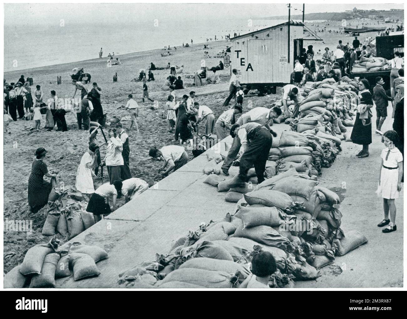 Urlauber füllen Sandsäcke an einem Strand an der Ostküste Großbritanniens in der Woche nach der Kriegserklärung im September 1939. Datum: 1939 Stockfoto