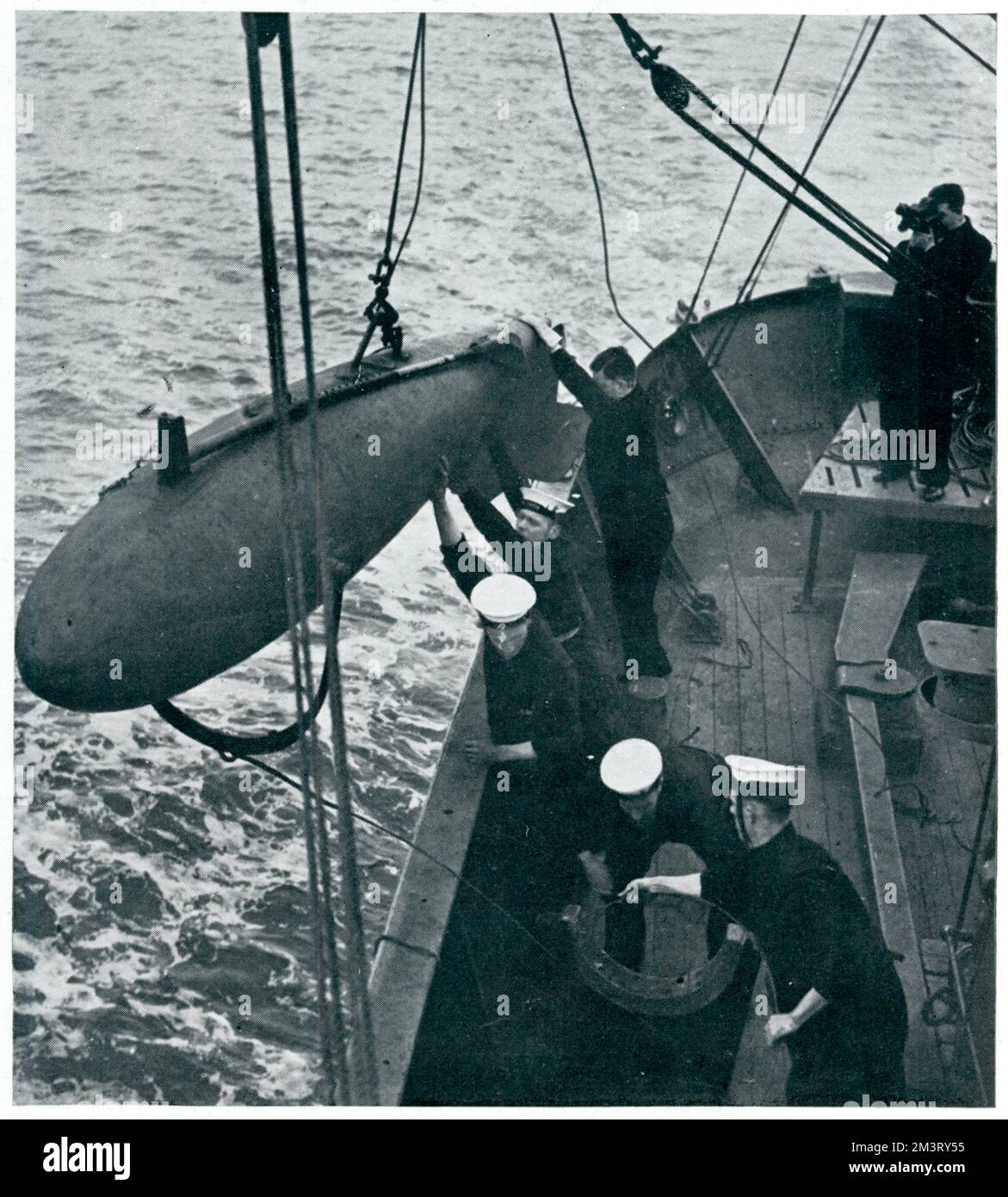 1938 begann ein Programm zur Ausbildung von Fischern als freiwillige Minenräumer und wurde genutzt, um der Marine die Konzentration an anderer Stelle zu ermöglichen. Dieses Foto zeigt die Auszubildenden, die ihren Parvan über Bord schieben, der verwendet wurde, um die Anlegestellen von Unterwasserminen zu durchtrennen. Datum: 1939 Stockfoto