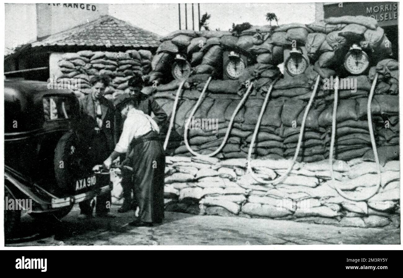 Ein extremes Beispiel für Sandsäcke in Erwartung von Luftangriffen in einer Garage in Nord-London. Die Sphärenwitze, dass "Autofahrer zweimal nachsehen müssen, bevor sie die Benzinpumpen erkennen", loben jedoch das "effiziente Sandsack-System". Datum: 1939 Stockfoto