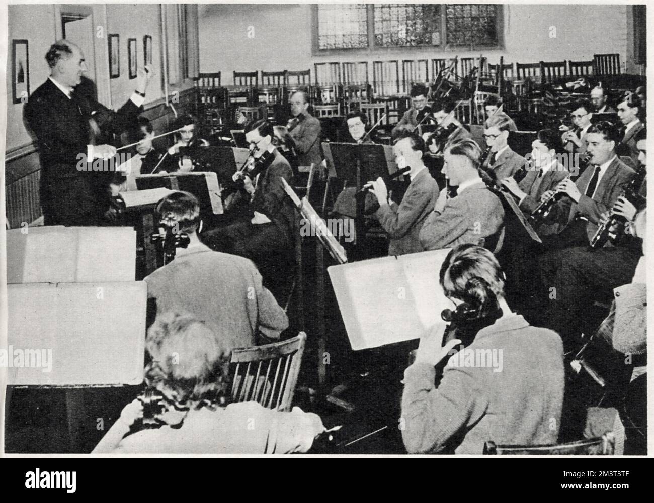 Mr. Allen leitet das Schulorchester in der Musikschule am Wellington College. Stockfoto