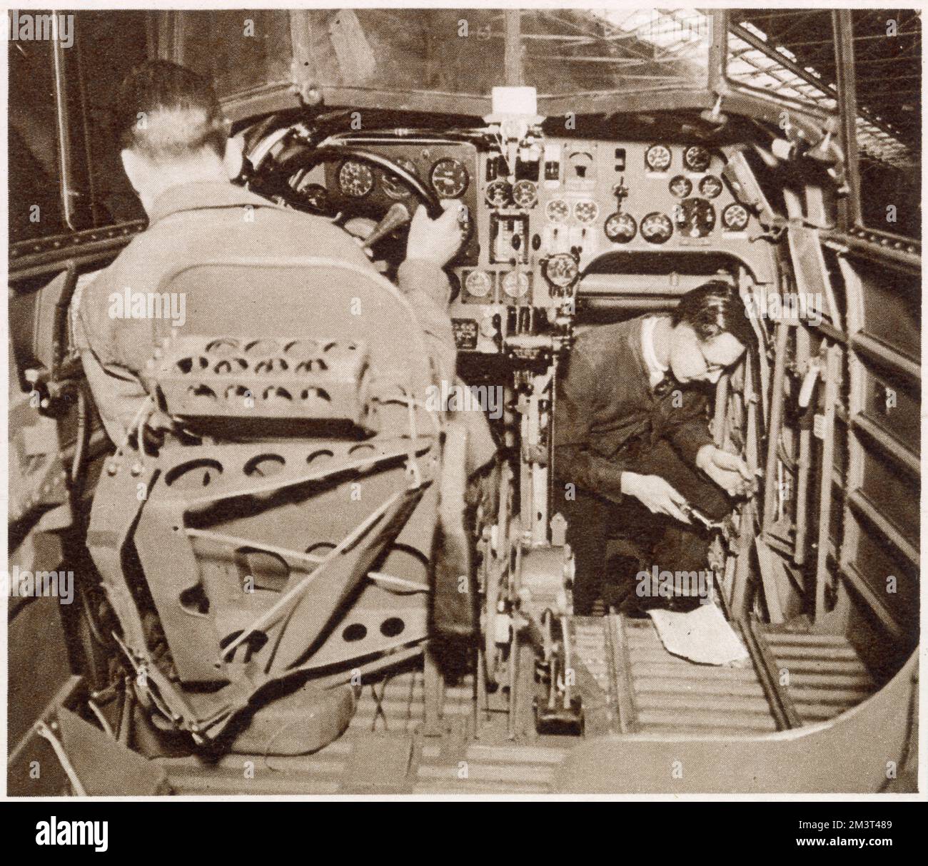 Ich führe Tests in einem fertigen Whitley-Bomber in Armstrong Whitworth in Coventry durch. Männer, die die Kontrollen im Cockpit des Piloten inspizieren. Stockfoto