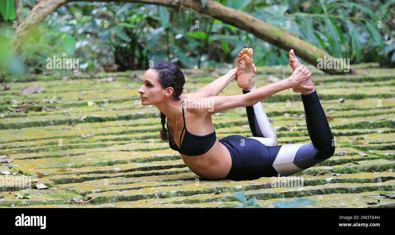 Yogi-Sportlerin, die Yoga im Freien trainiert und Froschposierung macht Stockfoto