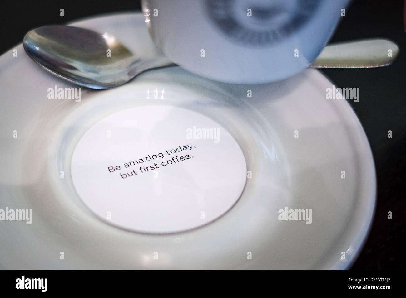 Kleine runde Karte mit einer inspirierenden Botschaft unter einer Kaffeetasse. Stockfoto