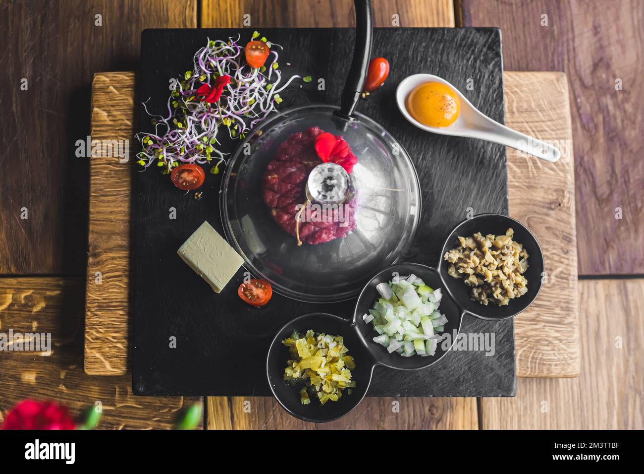 Traditionelle polnische Küche auf moderne Weise. Geräucherte Rindertartar eine Steinplatte mit verschiedenen Zutaten. Draufsicht. Hochwertiges Foto Stockfoto