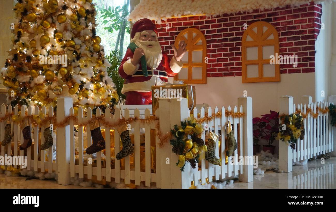 Statue des Weihnachtsmanns neben dem Weihnachtsbaum mit seinen Schnickschnack Stockfoto